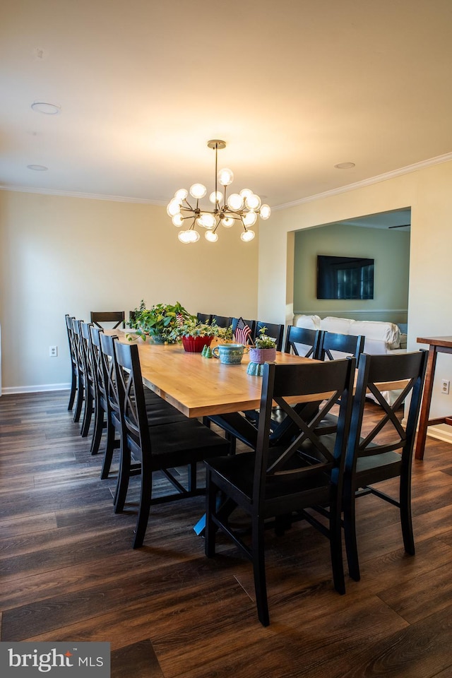 dining area with baseboards, ornamental molding, dark wood-style flooring, and an inviting chandelier