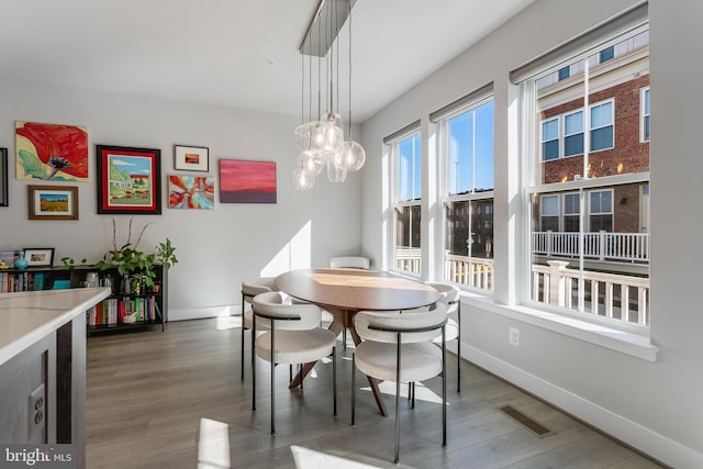 dining room with wood finished floors, visible vents, and baseboards