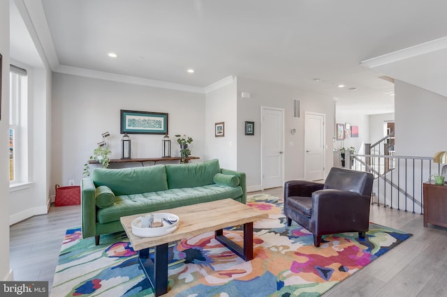 living room with baseboards, visible vents, wood finished floors, crown molding, and recessed lighting