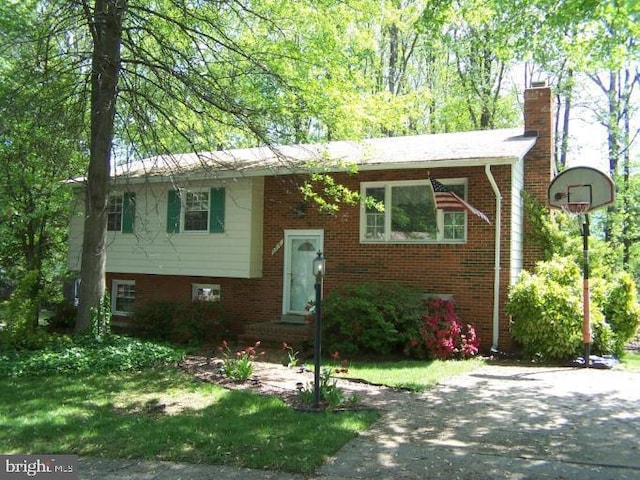 raised ranch with brick siding and a chimney