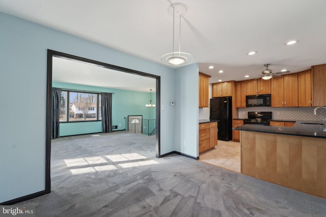 kitchen with dark countertops, light carpet, a sink, and black appliances