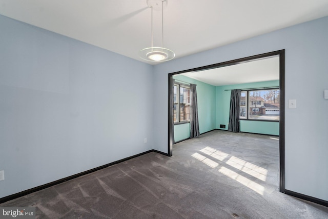 unfurnished room featuring carpet floors and baseboards