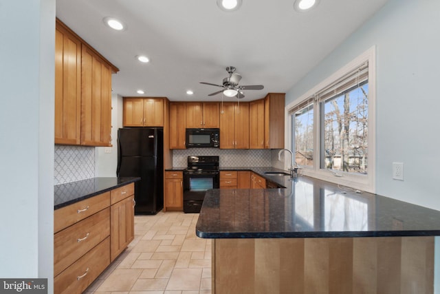 kitchen featuring black appliances, backsplash, a peninsula, and a sink