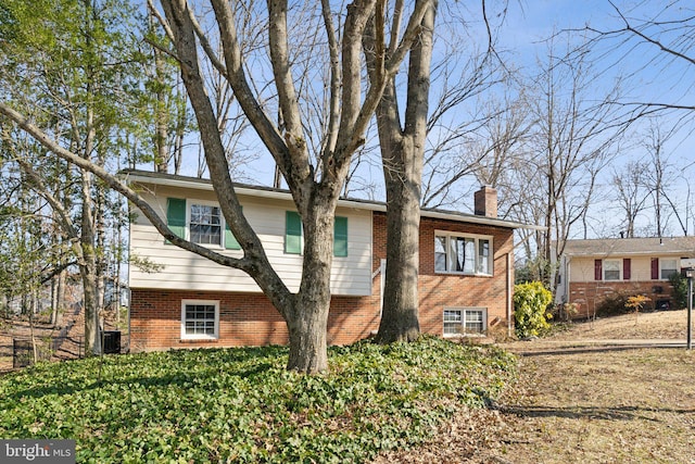 view of side of home featuring brick siding and a chimney