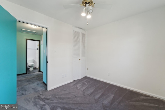 unfurnished bedroom featuring a ceiling fan, baseboards, a closet, dark carpet, and attic access