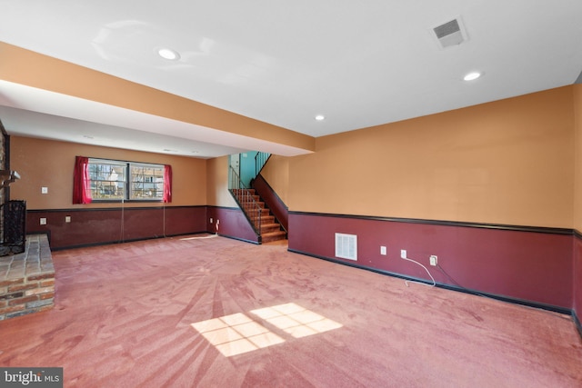 interior space with a wainscoted wall, stairway, carpet, and visible vents