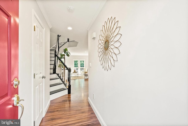 foyer entrance featuring recessed lighting, ornamental molding, wood finished floors, baseboards, and stairs