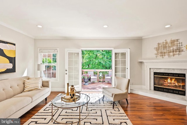 living area with crown molding, dark wood-style flooring, a fireplace, and baseboards