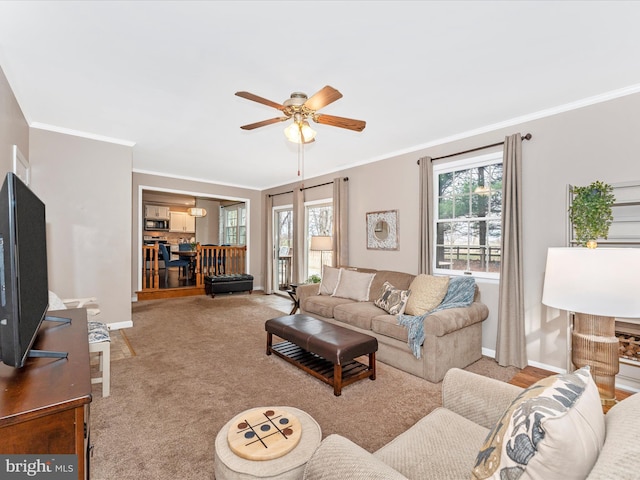 living area with light carpet, ornamental molding, and baseboards