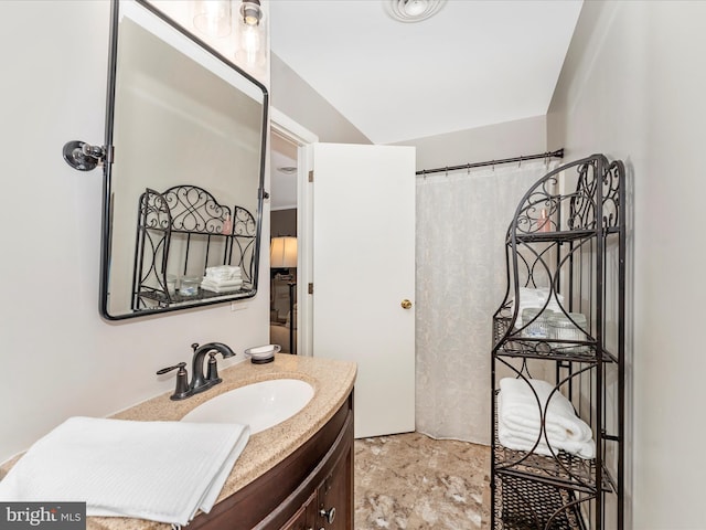 bathroom featuring stone finish flooring and vanity