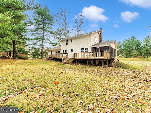 back of property featuring a chimney, a sunroom, a yard, and a deck