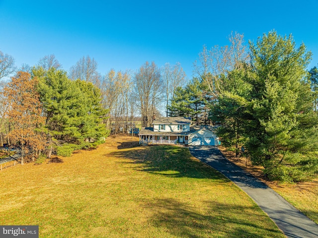 view of front of property with driveway, a porch, and a front yard