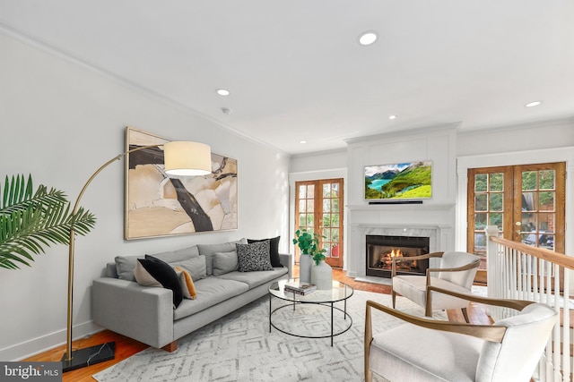 living area featuring light wood finished floors, recessed lighting, a high end fireplace, and french doors