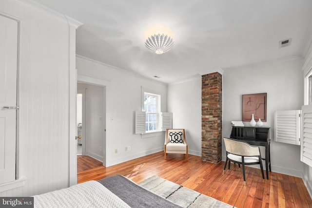 bedroom featuring light wood-type flooring, visible vents, crown molding, and baseboards