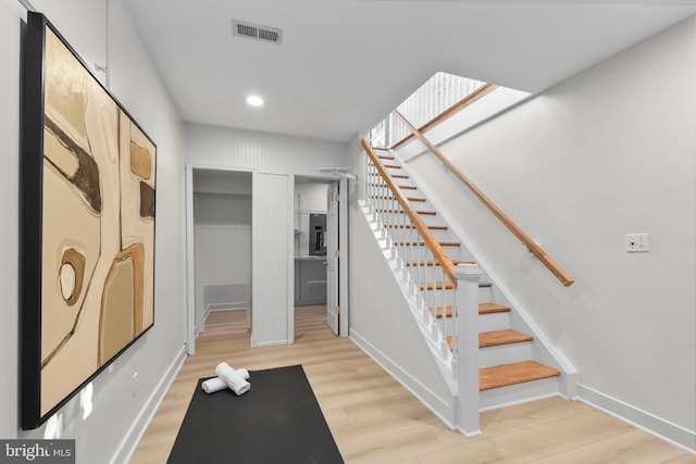 stairway with recessed lighting, visible vents, baseboards, and wood finished floors