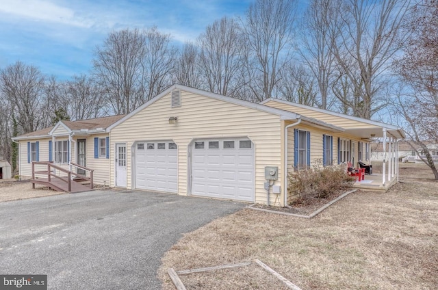 ranch-style home featuring aphalt driveway and an attached garage