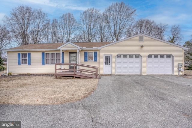 single story home featuring a garage and aphalt driveway