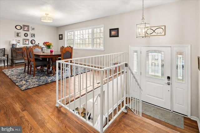 entryway with wood finished floors and a notable chandelier