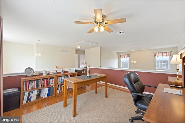 office space with visible vents, ceiling fan, and wood finished floors