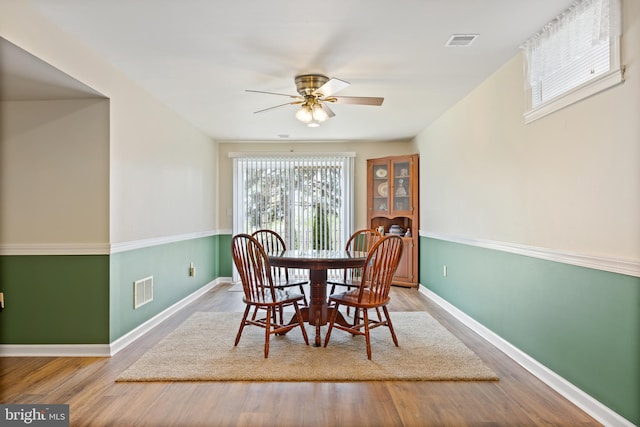 dining space featuring wood finished floors, visible vents, and a ceiling fan