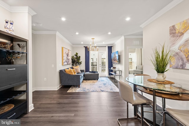 living area featuring ornamental molding, recessed lighting, dark wood-type flooring, and an inviting chandelier