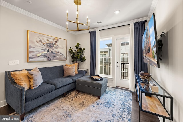 living room featuring dark wood-type flooring, an inviting chandelier, visible vents, and crown molding