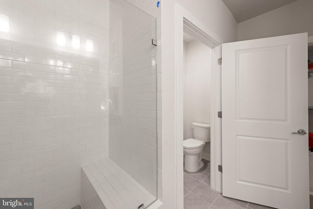 full bathroom with a stall shower, toilet, and tile patterned floors