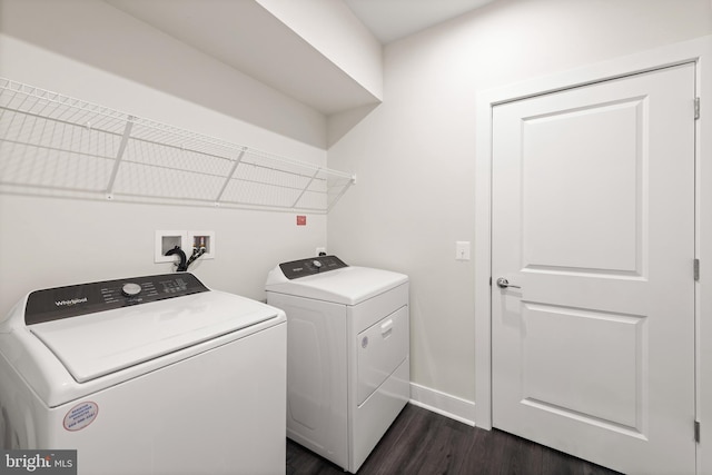 clothes washing area featuring dark wood-style floors, washer and dryer, laundry area, and baseboards