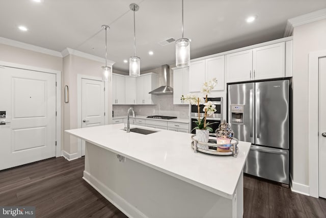 kitchen with an island with sink, wall chimney exhaust hood, stainless steel appliances, and a sink