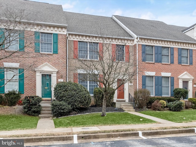 townhome / multi-family property with brick siding and a shingled roof