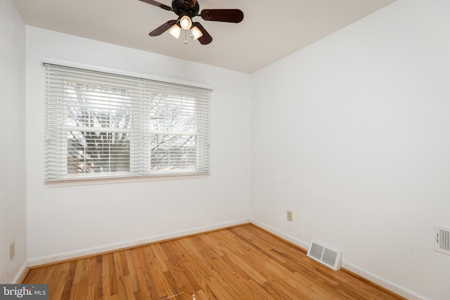 unfurnished room with light wood finished floors, a ceiling fan, visible vents, and baseboards