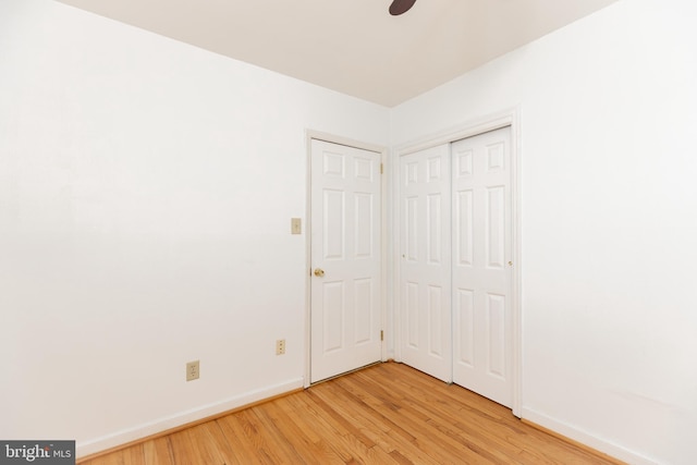 unfurnished bedroom with light wood-style floors, baseboards, and a closet