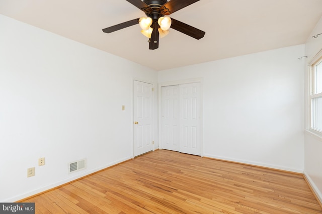 empty room with light wood-type flooring, baseboards, visible vents, and a ceiling fan