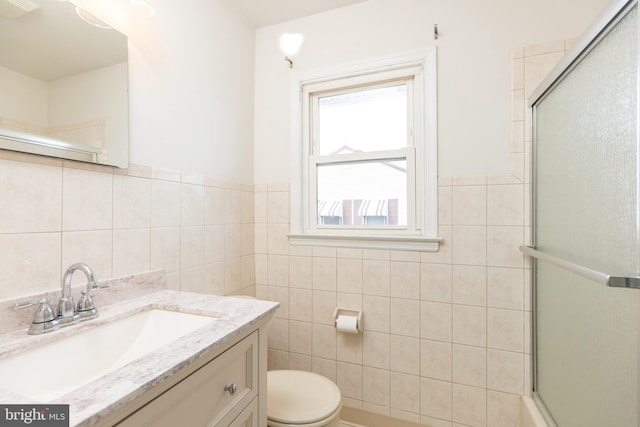 full bath featuring vanity, tile walls, toilet, and an enclosed shower