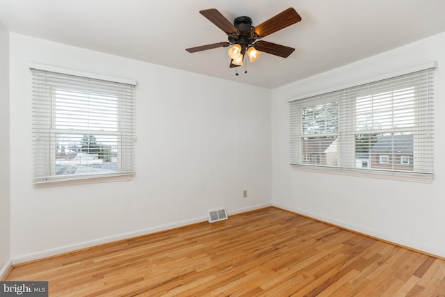 spare room with baseboards, visible vents, and light wood-style floors