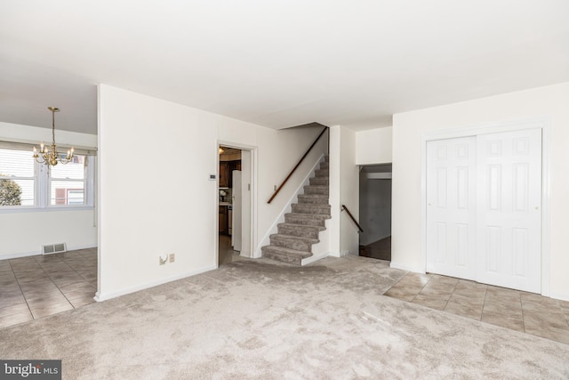 tiled empty room with a chandelier, carpet floors, visible vents, baseboards, and stairway