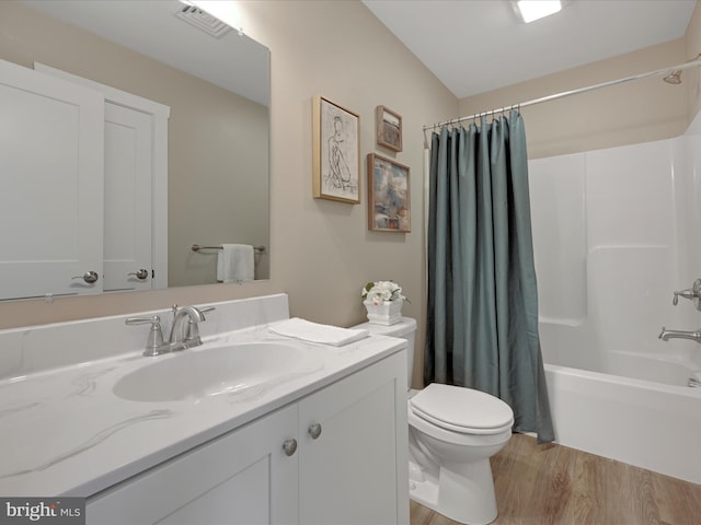 full bath with visible vents, toilet, wood finished floors, shower / bath combination with curtain, and vanity