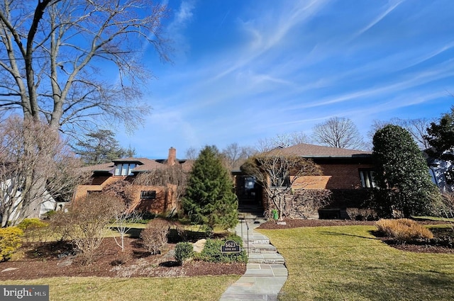 view of front of property featuring brick siding and a front lawn