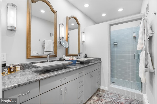 full bathroom featuring double vanity, a sink, visible vents, and a shower stall