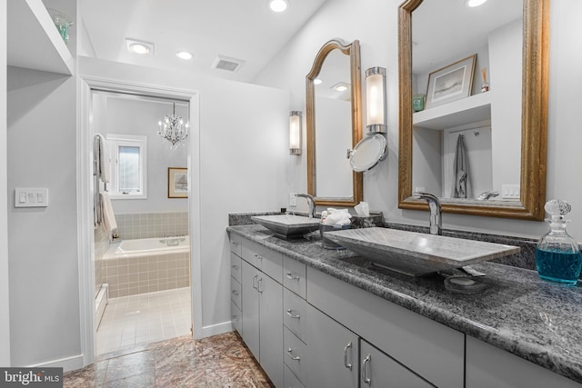 bathroom featuring tiled tub, visible vents, a sink, and double vanity