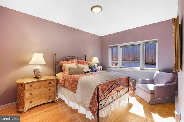 bedroom with baseboards and wood finished floors