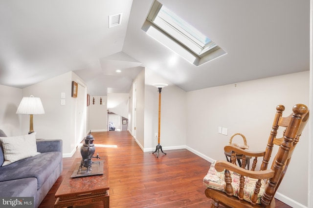 interior space featuring lofted ceiling with skylight, baseboards, visible vents, and wood finished floors