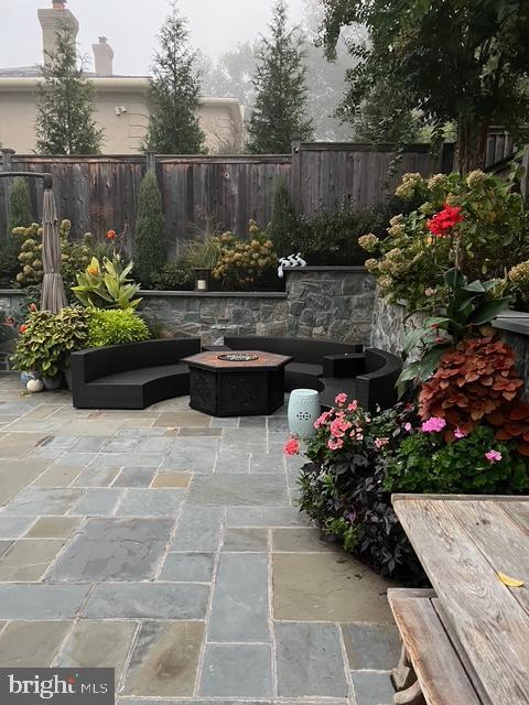 exterior space featuring an outdoor fire pit, a patio area, and fence