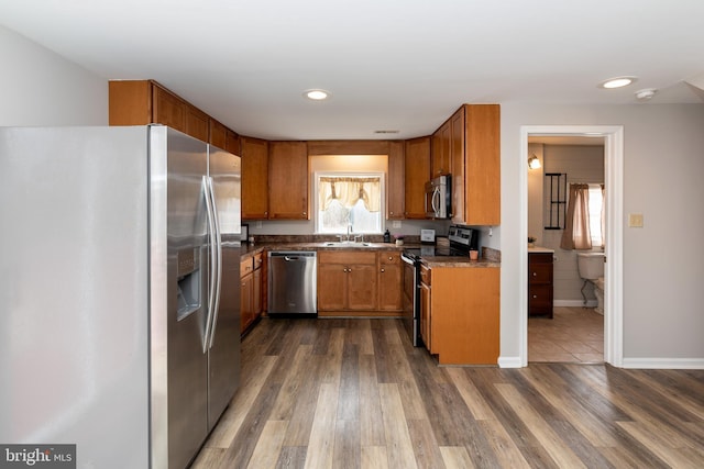 117 Quaker Neck Rd, Salem, NJ 08079 - kitchen featuring brown cabinetry, baseboards, dark wood-style flooring, a sink, and stainless steel appliances