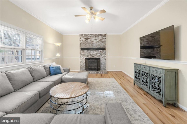 living room with a brick fireplace, baseboards, ornamental molding, and wood finished floors