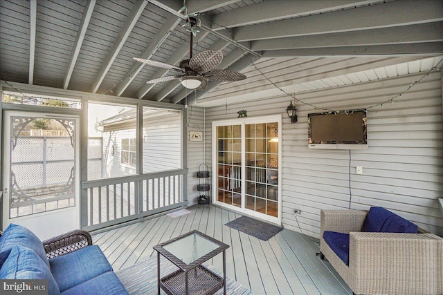 sunroom / solarium featuring vaulted ceiling with beams and a ceiling fan