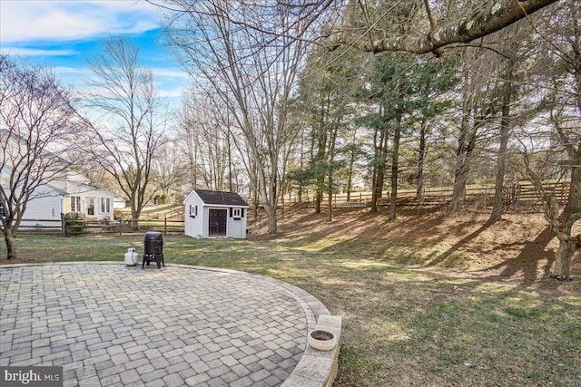 view of yard featuring a patio area, a shed, an outdoor structure, and fence