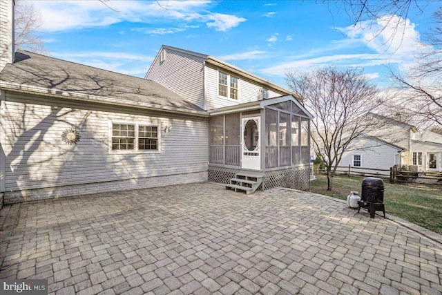 back of house featuring a patio area, fence, and a sunroom