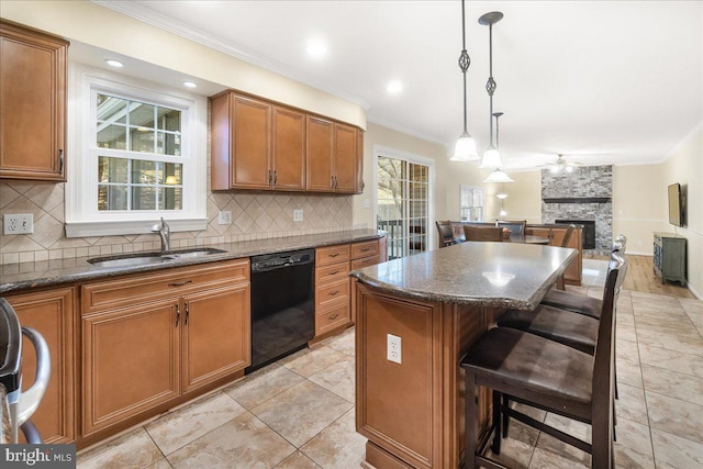 kitchen featuring a fireplace, a sink, black dishwasher, brown cabinets, and a center island