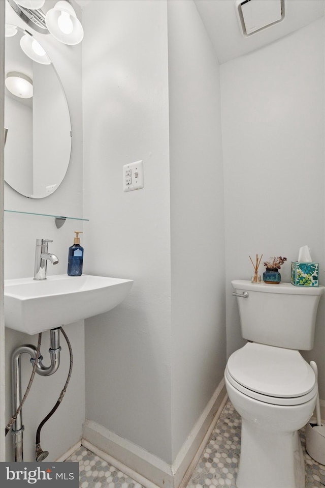 bathroom featuring tile patterned floors, toilet, and baseboards